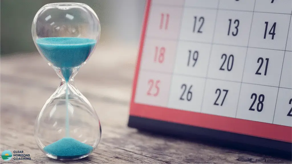 Image is of a sand egg-timer with the sand running through, next to a page of a calendar showing the days of the month